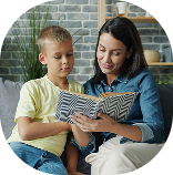 A boy and a woman reading a book